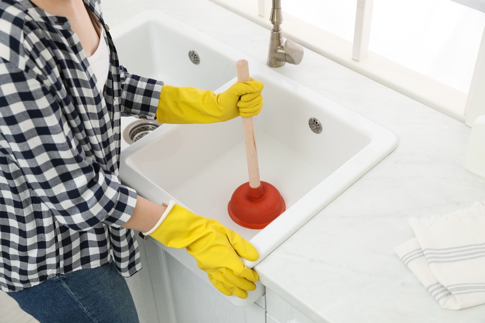 woman fixing plumbing problems in the home